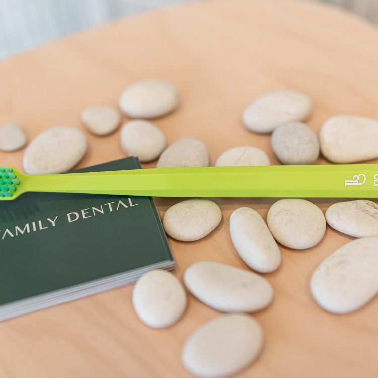 healthy gums - noosa family dental card and green tooth brush